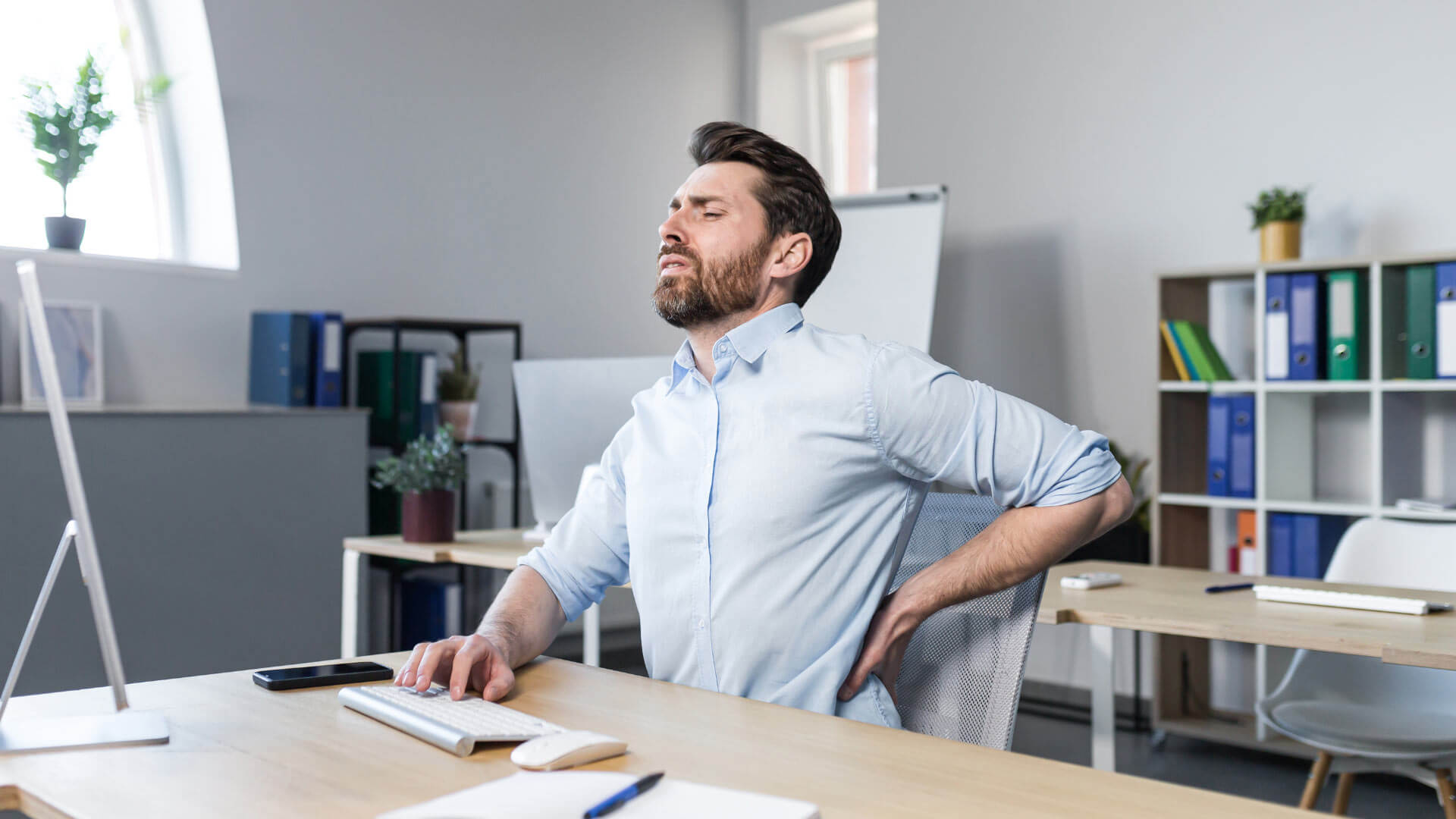 a working man experiencing a back neck pain